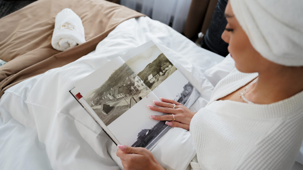 Detail na ženu listujúcu vo fotoalbume v hotelovej izbe